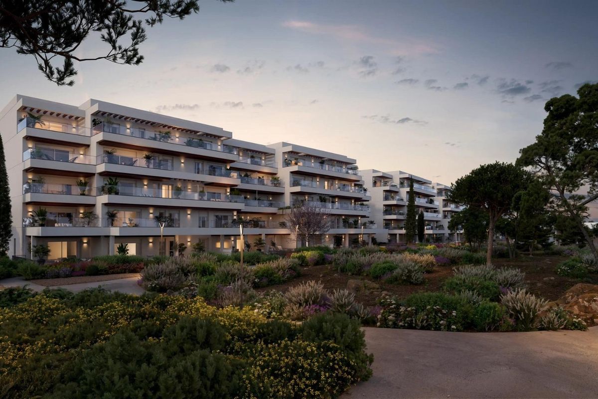 Modern appartementsgebouw bij schemering met weelderige tuinen in Denia, Costa Blanca North.