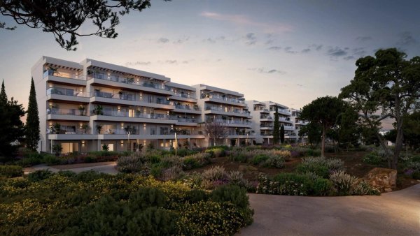 Buitenzicht op modern appartementencomplex in Denia, met meerdere balkons en weelderige tuinlandschappen.