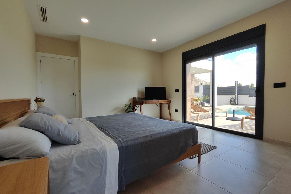 Modern bedroom with direct access to an outdoor seating area in a 3-bed villa in Pinoso, Costa Blanca South.