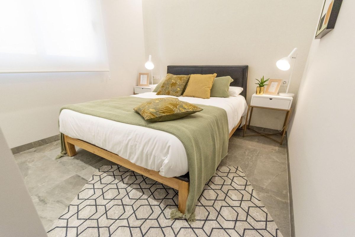 Gezellige slaapkamer met een groene deken en moderne decoratie, gelegen in een 3-slaapkamer villa in Pilar de La Horadada.