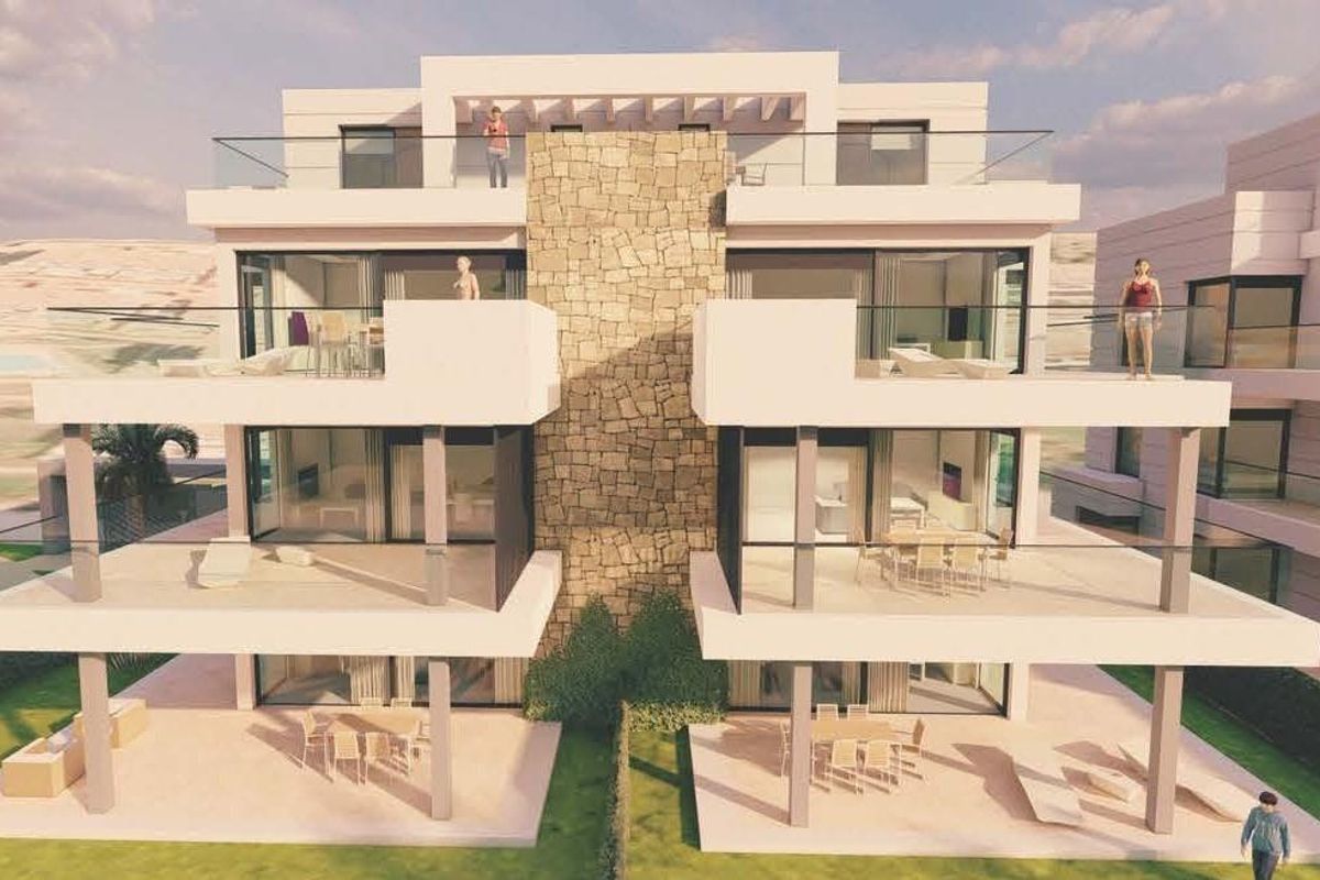 Vooraanzicht van een stijlvol appartementengebouw in Estepona, Costa del Sol met balkons en een stenen muur.