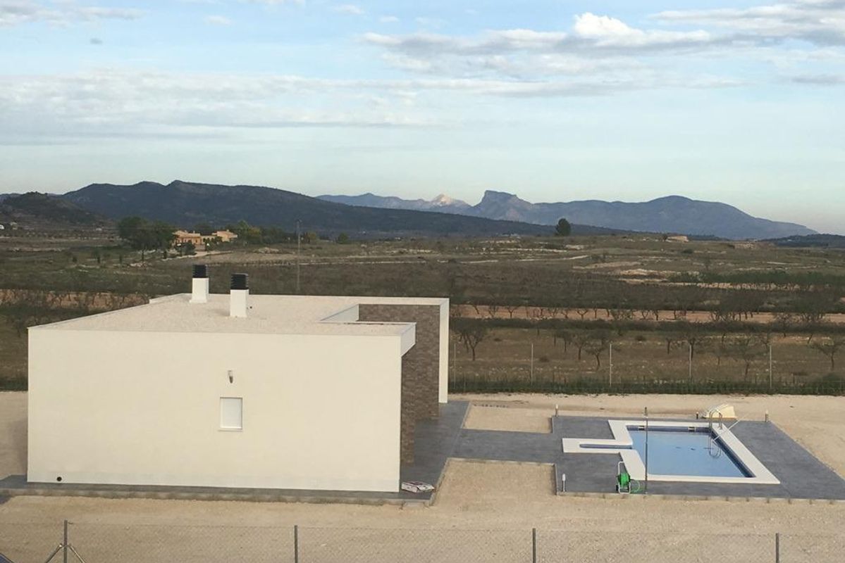 Zijaanzicht van een 3-slaapkamer villa met een zwembad, met uitzicht op het landschap van Pinoso, Costa Blanca Zuid.