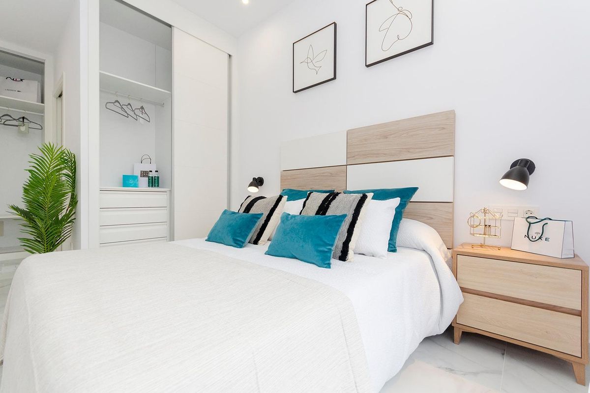 Uitnodigende slaapkamer met een stijlvolle bed en bergruimte in een 3-slaapkamer villa in Torrevieja, Costa Blanca.
