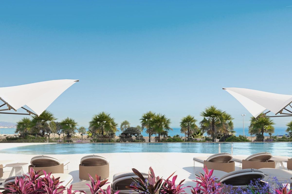 Mooie uitzicht vanaf het zwembadgebied op palmbomen en het strand in Málaga, Costa del Sol, perfect voor ontspanning.