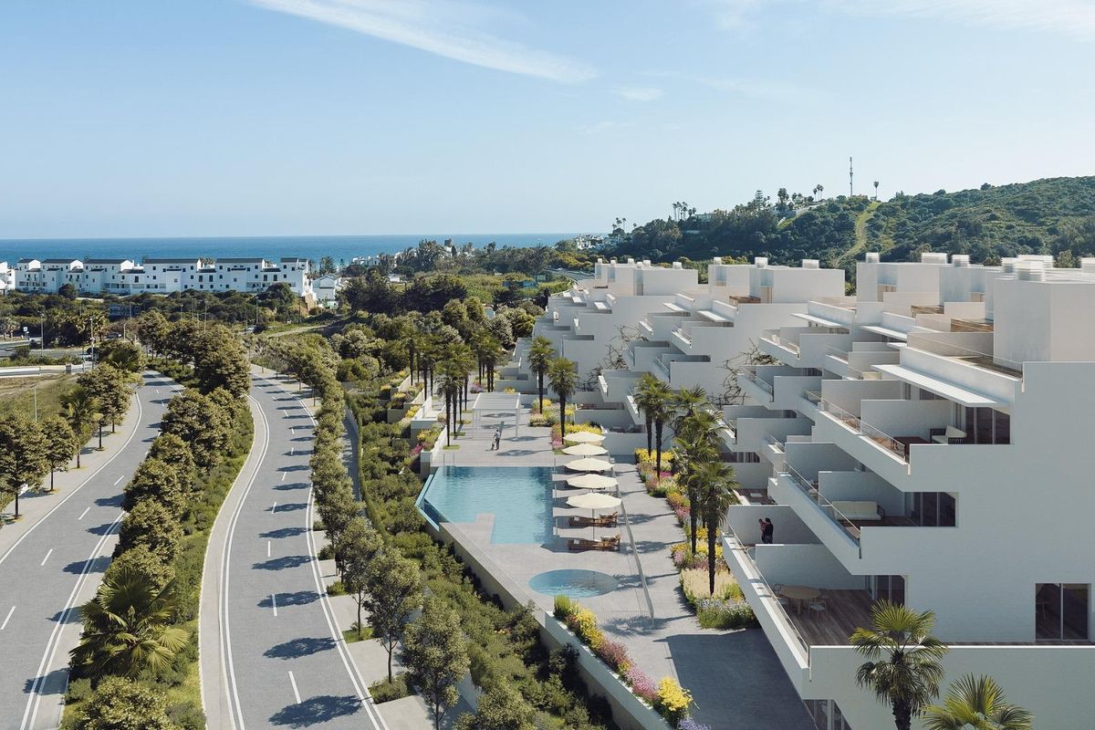 Luchtfoto van een modern appartementencomplex in Estepona met een zwembad en palmbomen in de buurt.