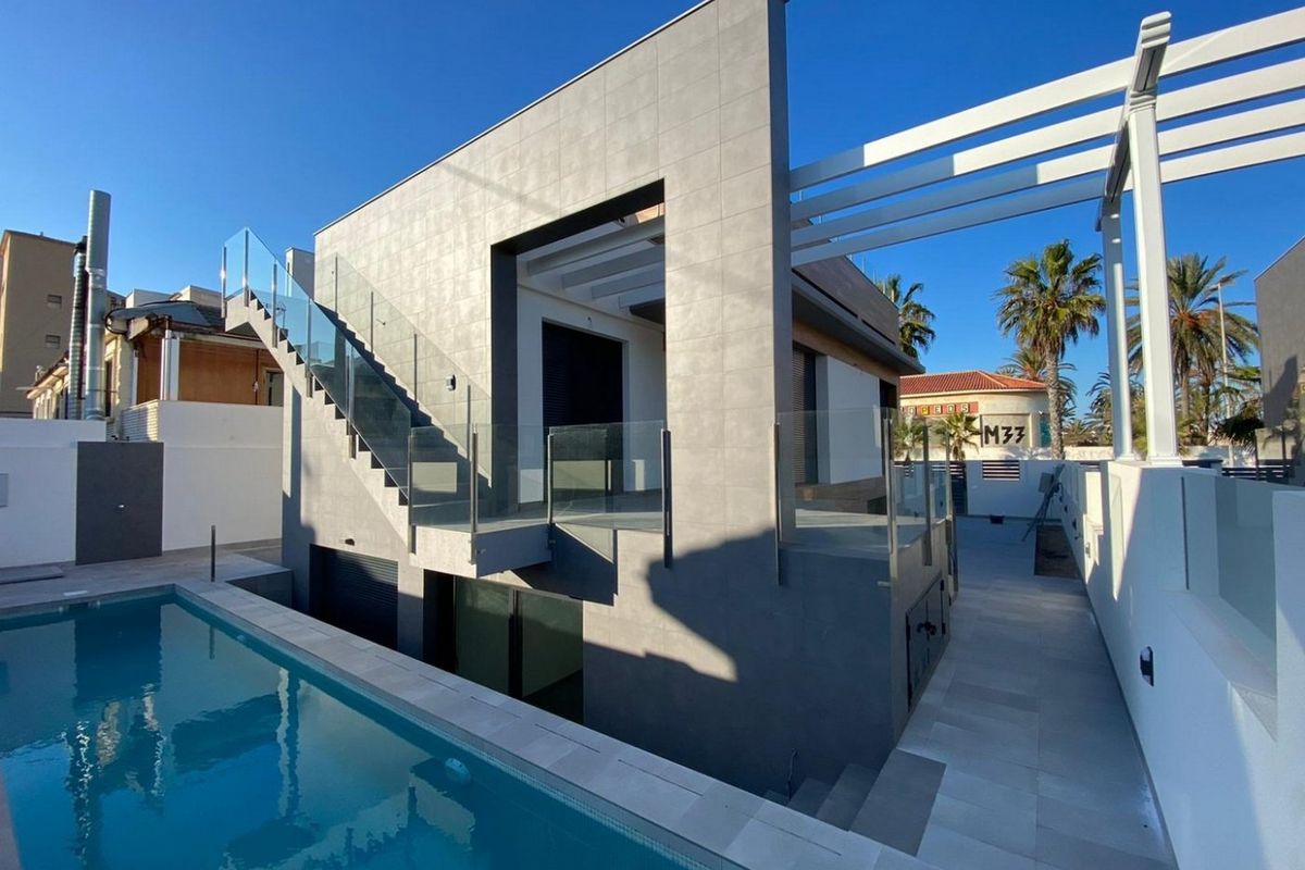 Stijlvol exterieur van een 4-slaapkamer villa in Torrevieja met een zwembad en moderne architectuur in de zon.
