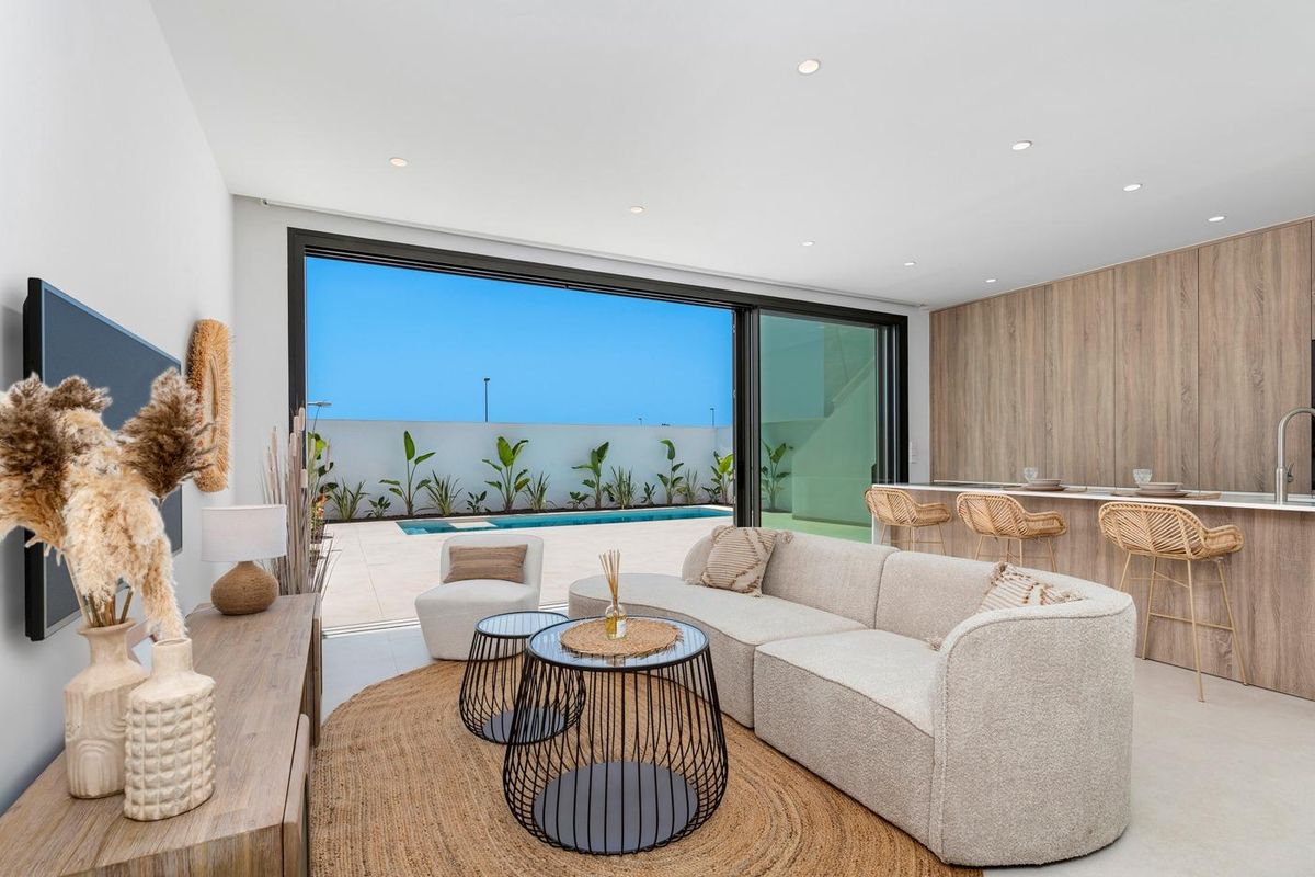 Ruime woonkamer met eet- en barruimte met uitzicht op het zwembad in een 3-slaapkamer townhouse in Los Alcazares.