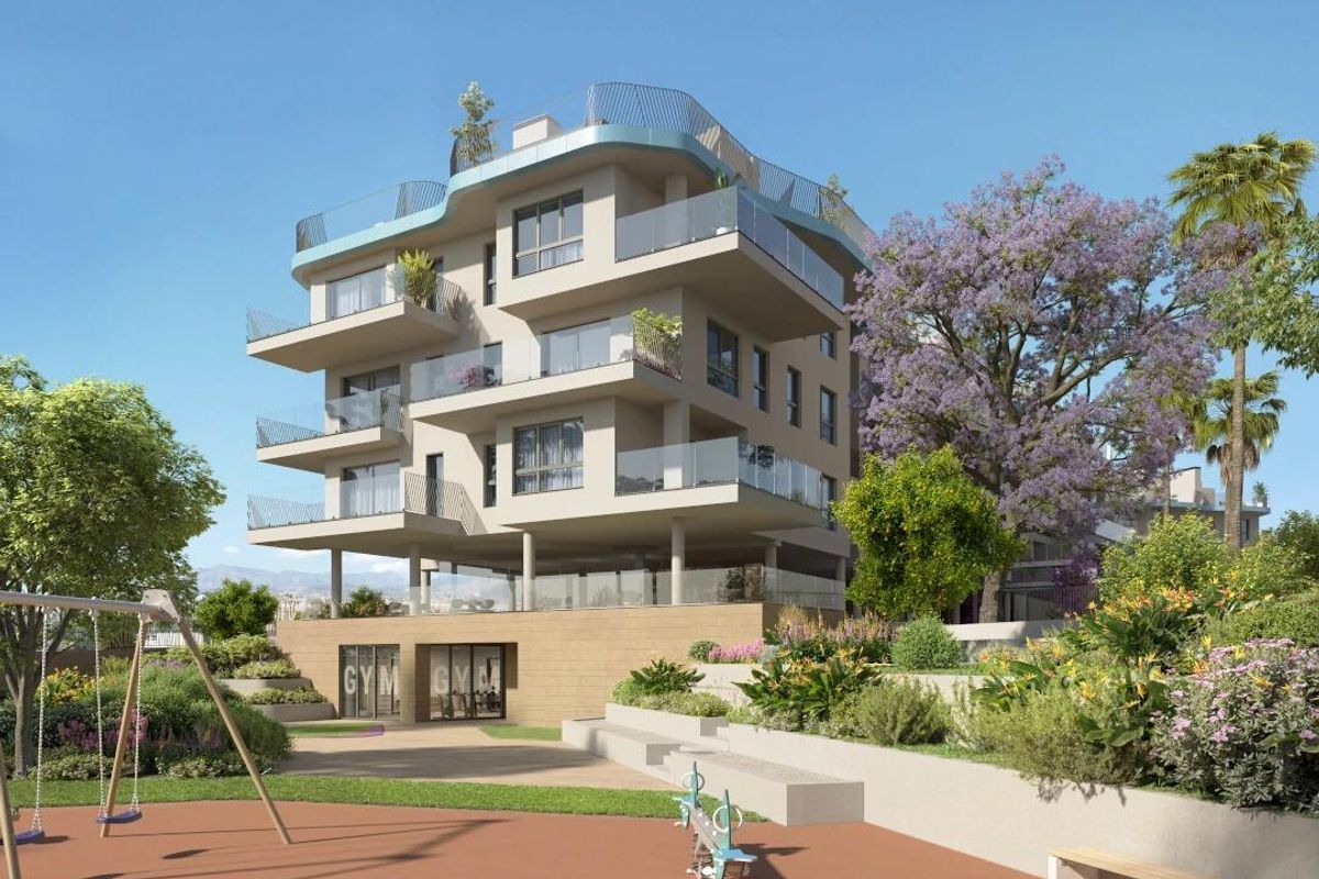 Buitenzicht op een stijlvol appartementencomplex met speeltuin in Villajoyosa, Costa Blanca Noord.
