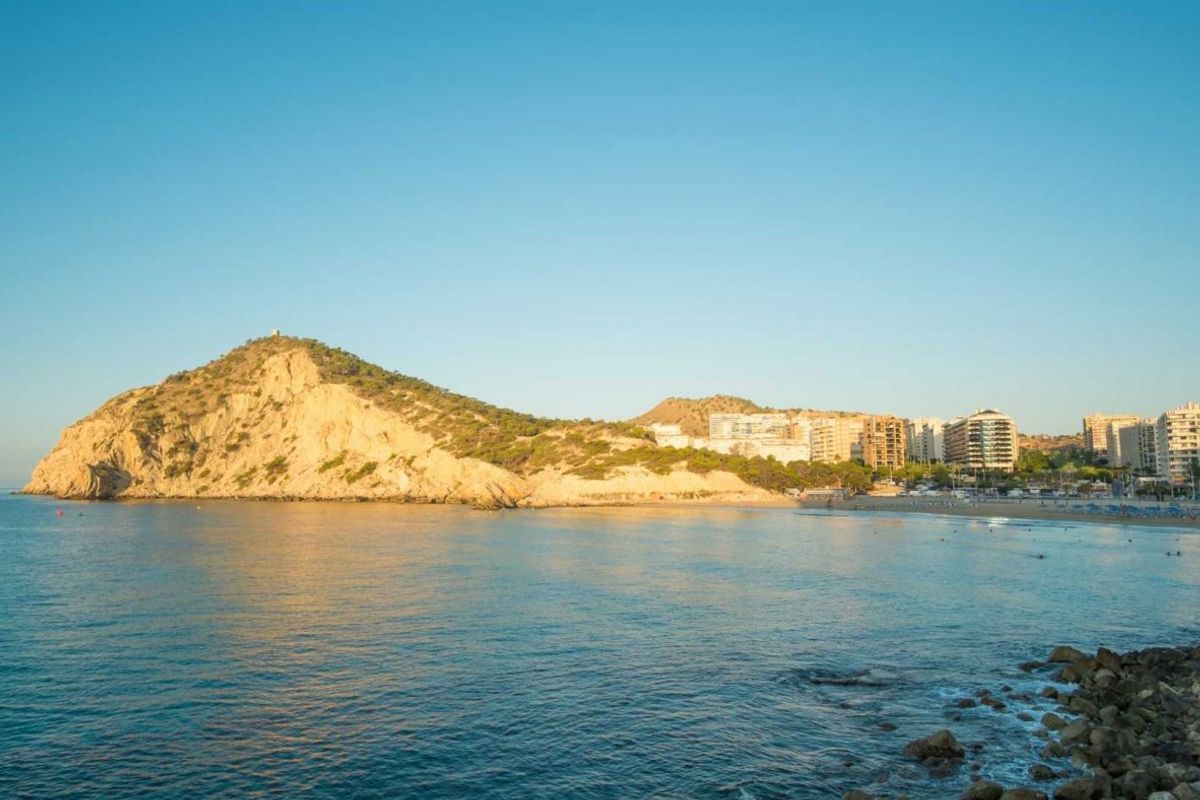 Indrukwekkend uitzicht op de kust met rotsachtige heuvels en strandontwikkelingen in Finestrat, Spanje.