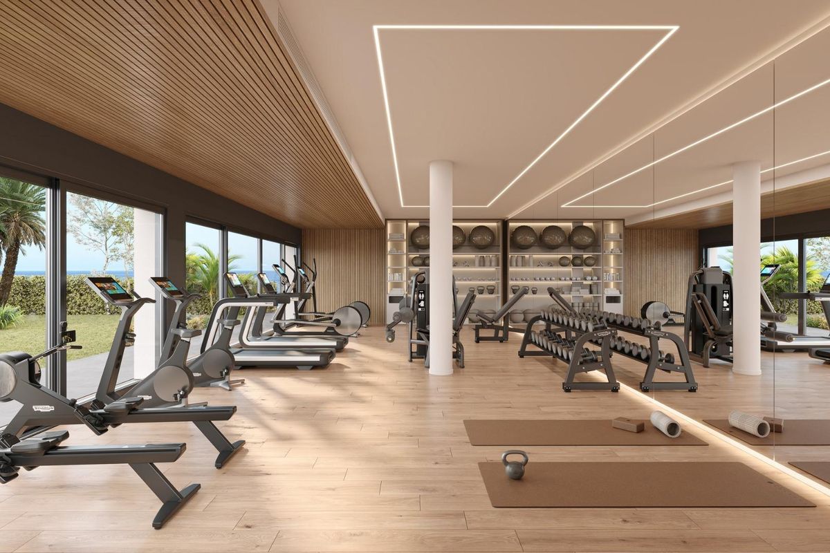 Moderne fitnessruimte met apparatuur met uitzicht op weelderig groen in een vastgoed in Casares.