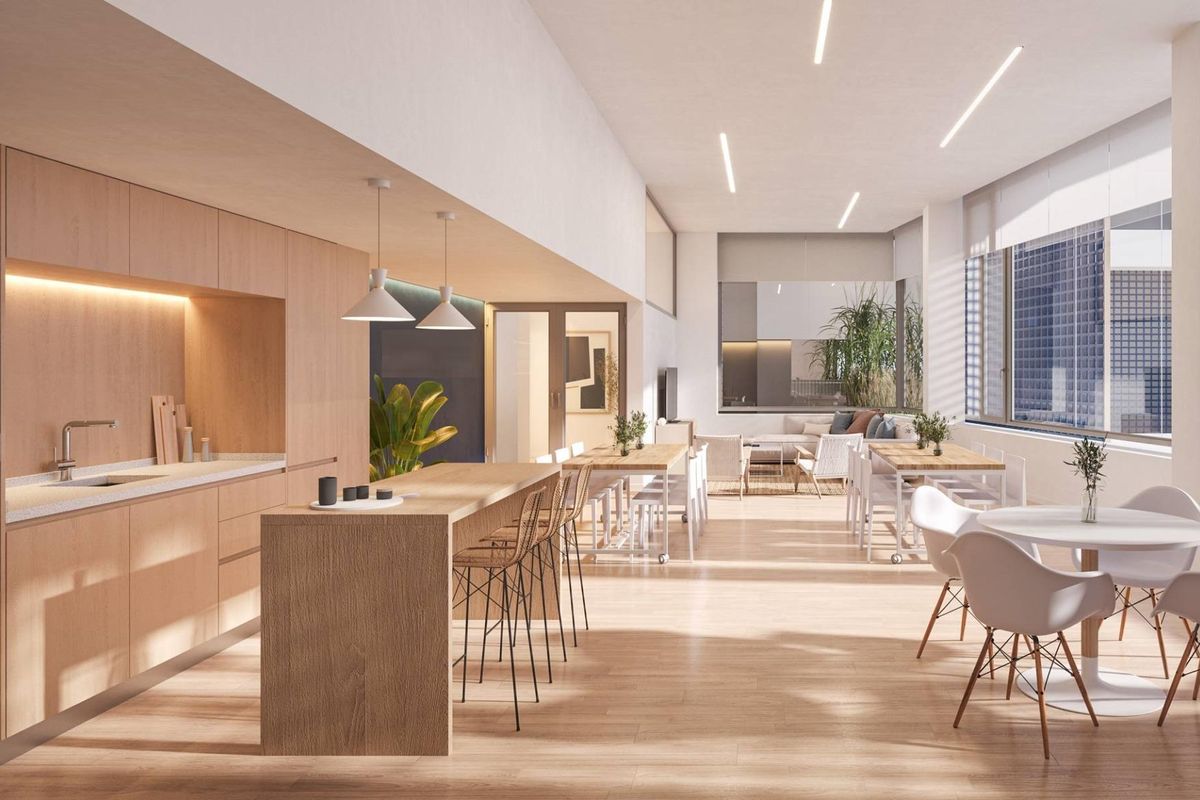 Spacious communal dining area with a modern kitchen, designed for gatherings in an Alicante apartment complex.
