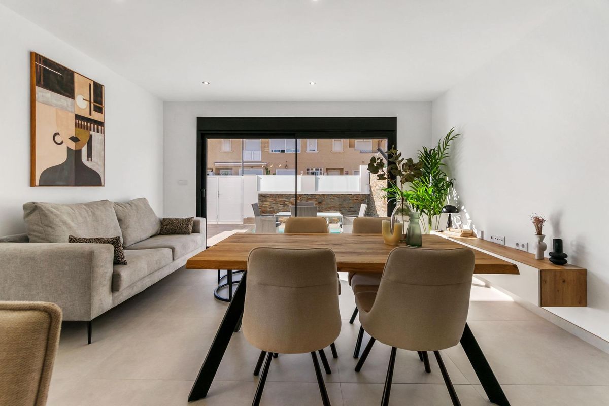 Stijlvolle woonkamer met een gezellige bank en eettafel. Een heldere ruimte in de townhouse in San Pedro del Pinatar.
