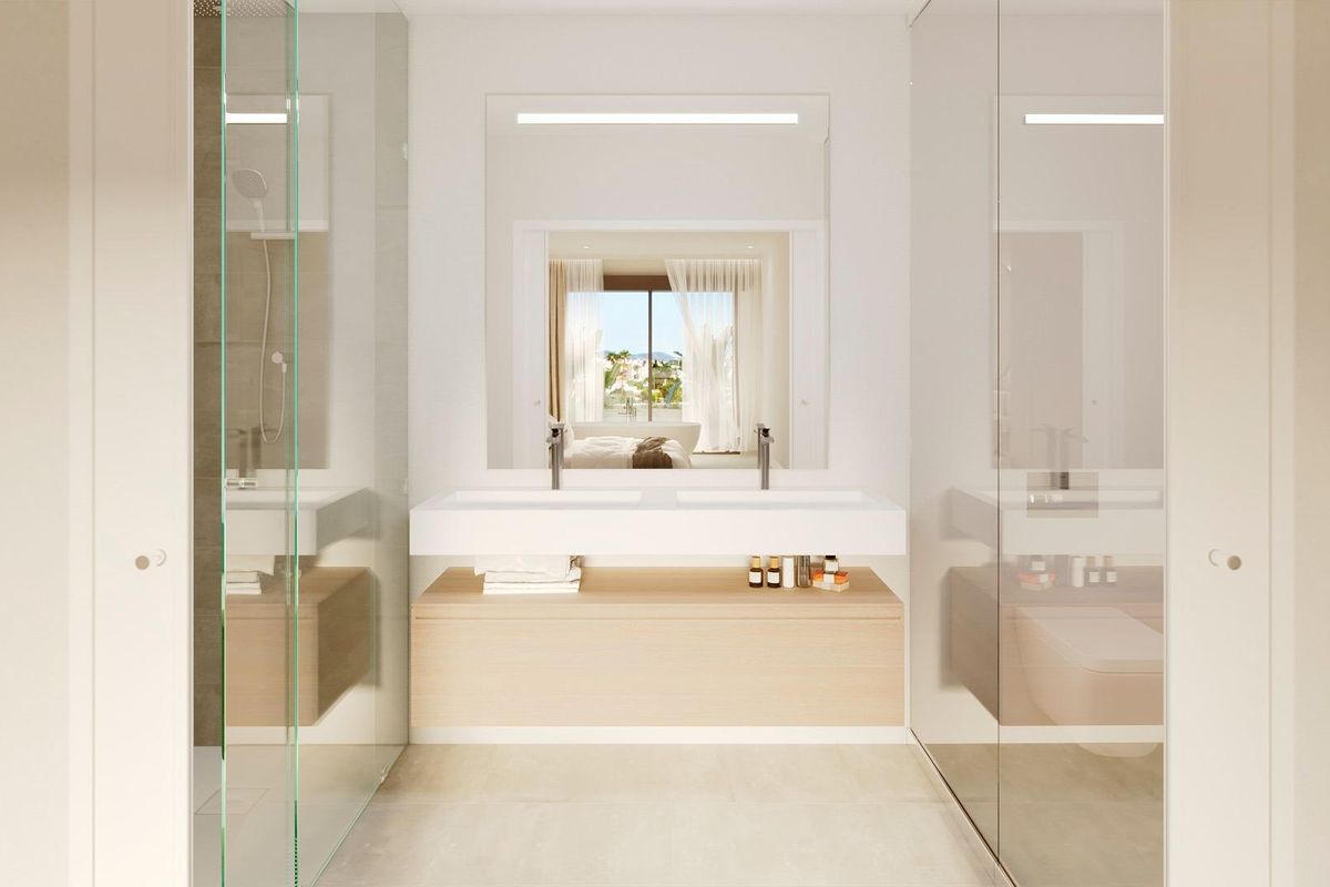 Moderne badkamer met dubbele wastafels en chique ontwerp, met uitzicht op de tuinen in de stadwoning van Fuengirola.