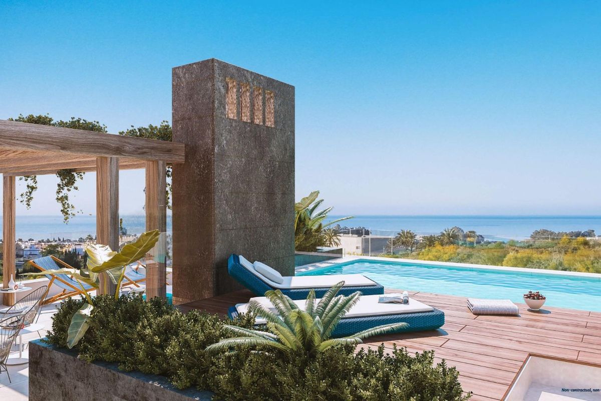 Ontspannend terras met ligstoelen en panoramisch zeezicht vanaf een chique herenhuis in Marbella, Spanje.