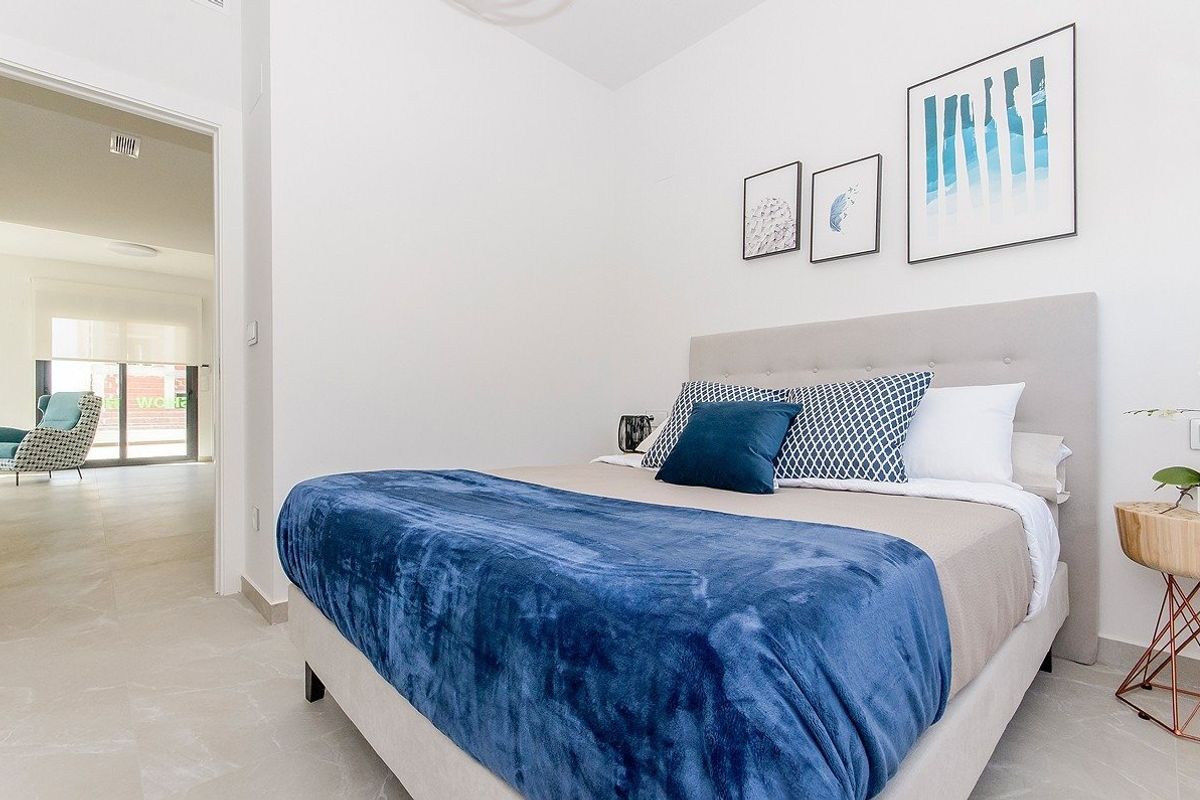 Stijlvolle tweede slaapkamer met moderne meubels en toegang tot de tuin in deze bungalow in San Miguel de Salinas.