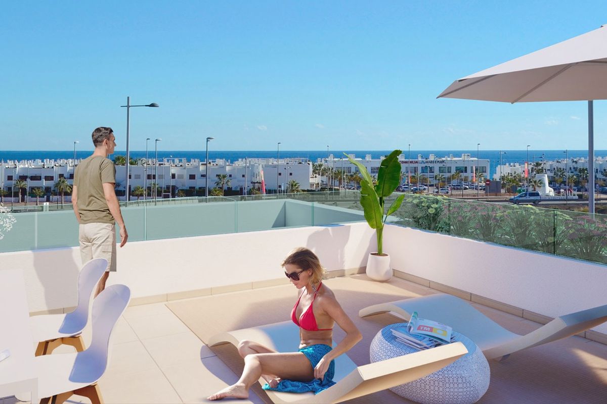 Dakterras met zeezicht, ligbedden en parasol in een moderne kustontwikkeling, Mar de Pulpi