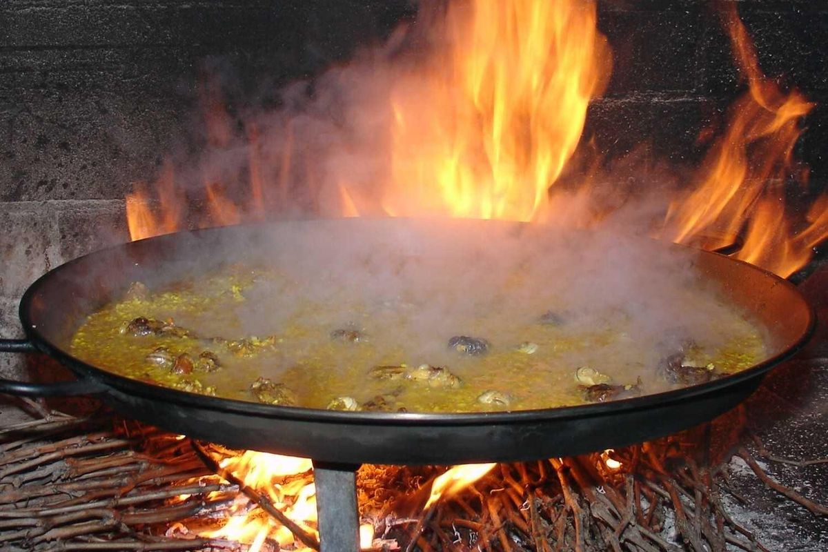 Traditional dish of paella being cooked over fire, showcasing local cuisine popular in Pinoso.