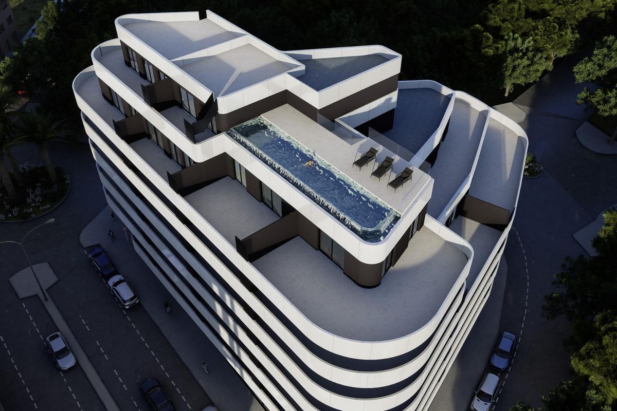 Luchtfoto van een modern appartementengebouw in Calpe met een dakterras met zwembad en ligstoelen.