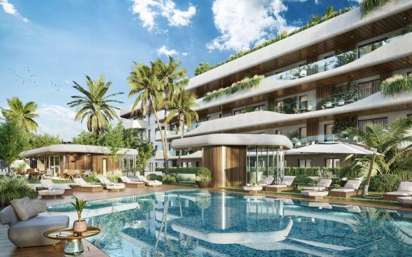 Buitenzicht van een modern appartementsgebouw met weelderig groen en een zwembad in Marbella, Costa del Sol.