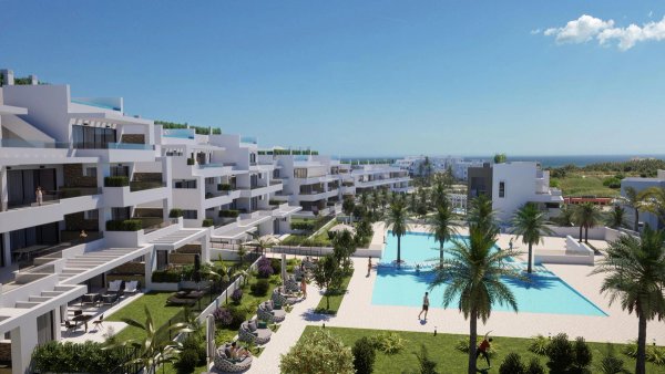 Modern appartementencomplex in Estepona, Costa del Sol met een groot zwembad en palmbomen in de tuin.