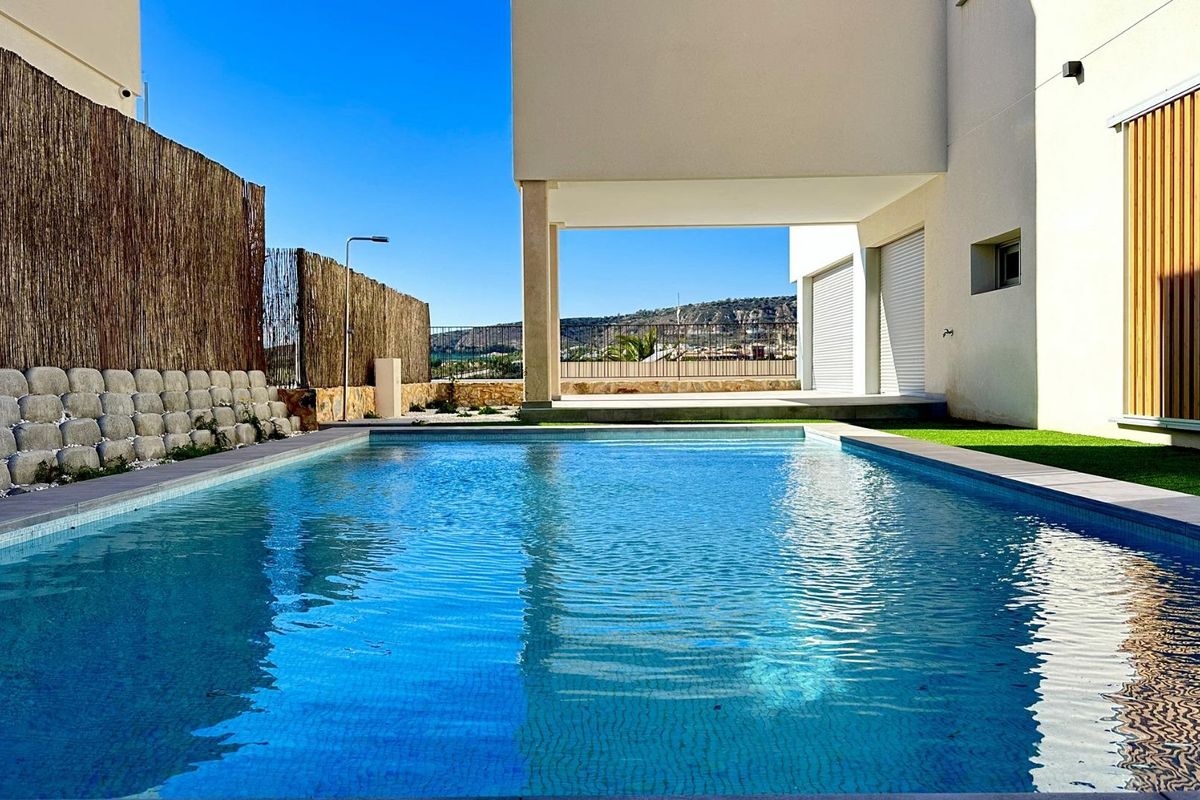 Uitzicht op een sprankelend zwembad met helderblauw water omgeven door moderne architectuur in Algorfa, Costa Blanca.