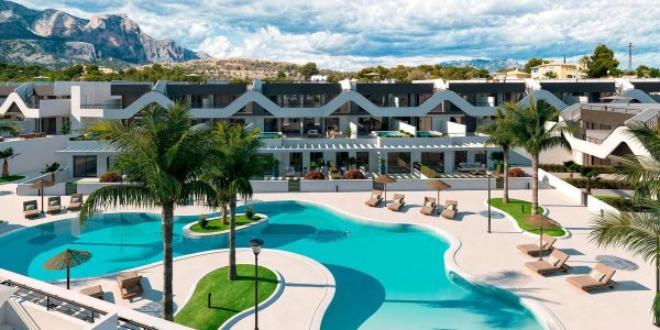 Luchtfoto van een moderne vastgoedcomplex met zwembaden en palmbomen in Alfas del Pi, Costa Blanca Noord.