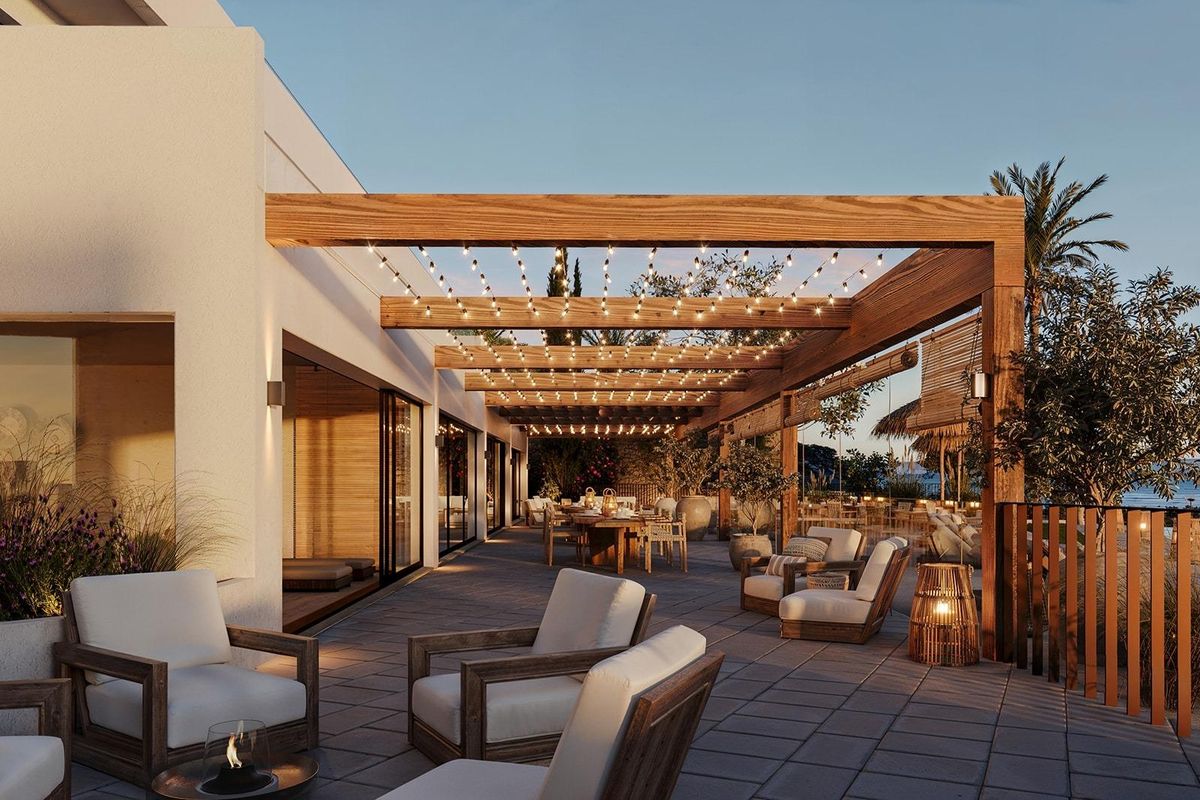 Buitenterras van een moderne penthouse in Mojacar met houten balken en zitplaatsen, met uitzicht op zee.