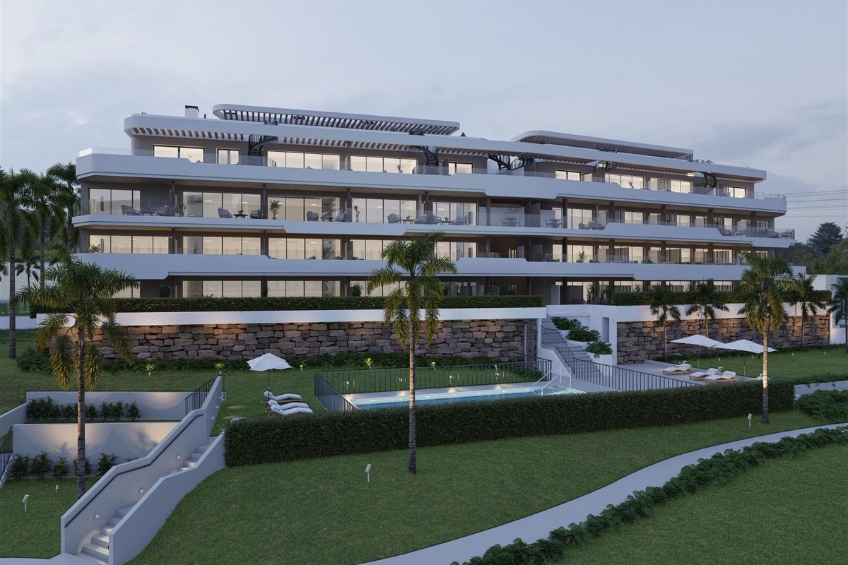 Moderne buitenkant van een nieuw wooncomplex in Manilva, Costa del Sol, met meerdere verdiepingen.