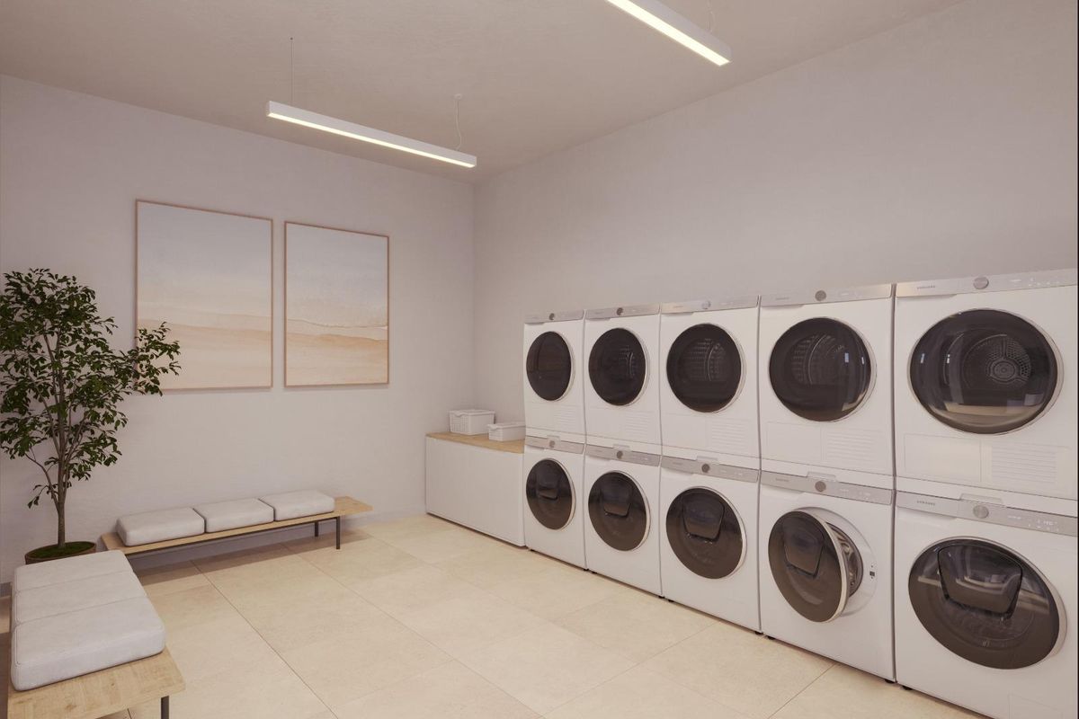 Functionele wasruimte in een penthouse in Fuengirola, uitgerust met moderne wasmachines en drogers.