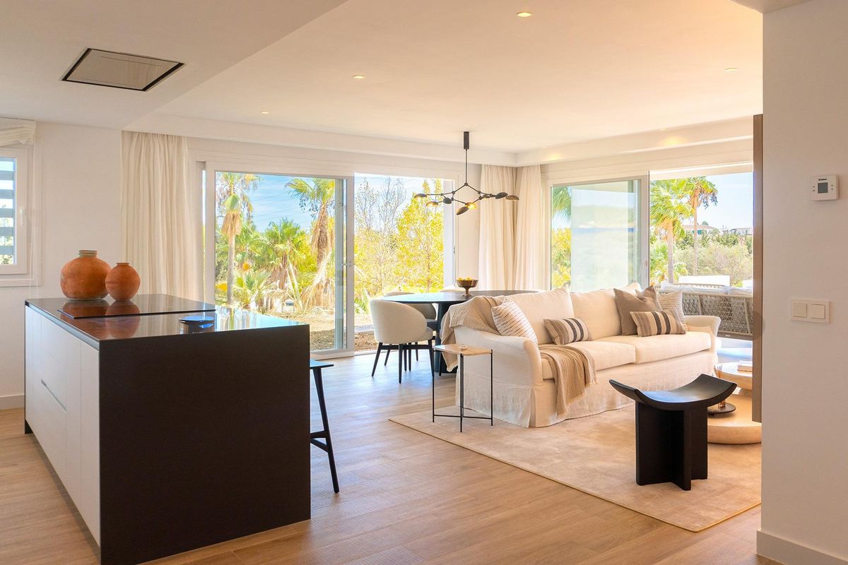 Gezellige woonkamer van het appartementen met twee slaapkamers in Casares, met grote glazen deuren naar buiten.