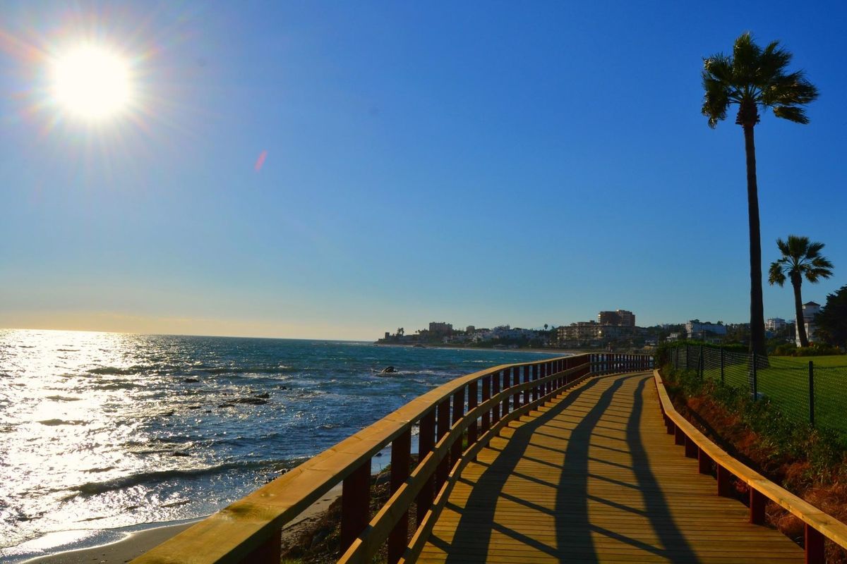 Promenade langs het strand in Mijas, Costa del Sol, met prachtig uitzicht op de oceaan en palmbomen.