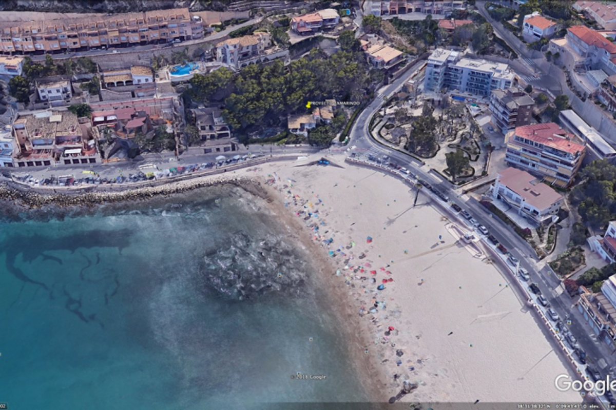 Luchtfoto van het strand van Benidorm, nabij het 3-slaapkamer penthouse, met levendige toeristische activiteit.