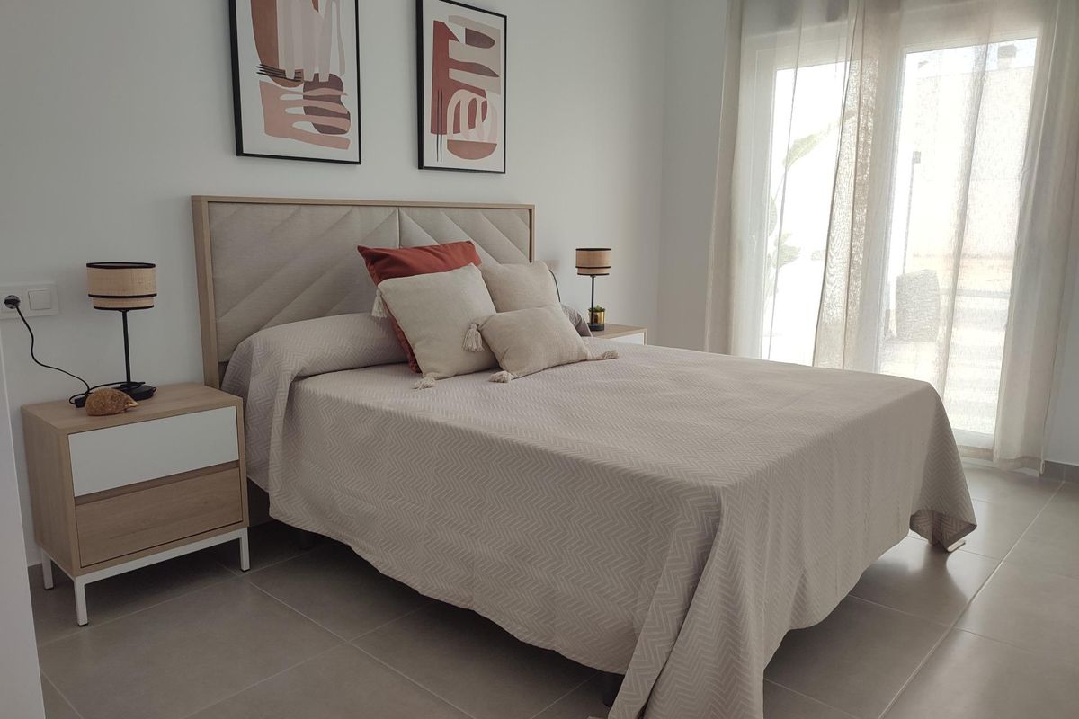 Gezellige hoofdslaapkamer met een bed met zachte beddengoed in een 3-slaapkamer townhouse in Torre Pacheco, Spanje.