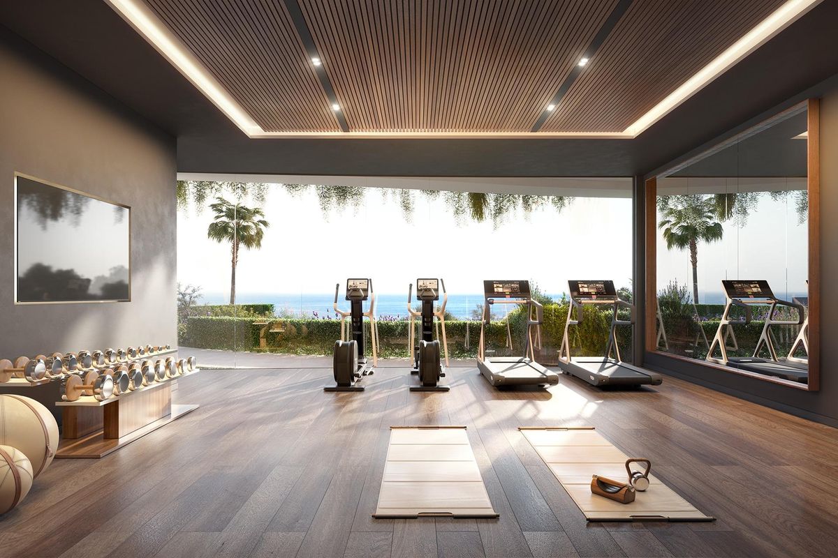 Goed uitgeruste thuisgym met fitnessapparaten en uitzicht op de tuin, gelegen in een 3-slaapkamer bungalow in Benalmádena.