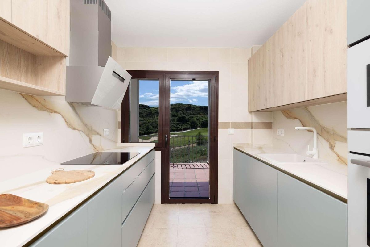 Soepele keukenontwerp met moderne apparatuur en uitzicht op het omliggende groen.