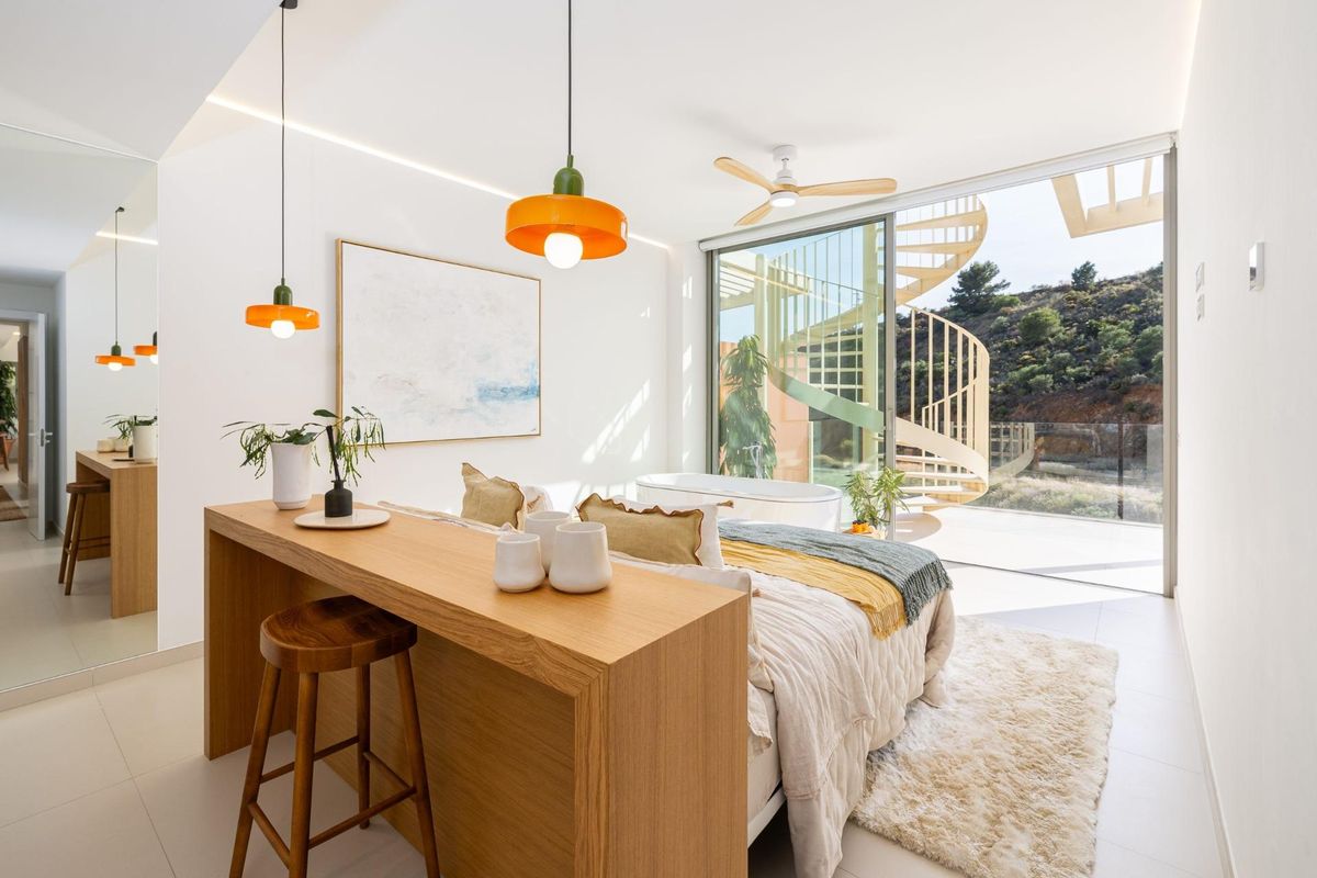 Heldere slaapkamer in een penthouse met uitzicht en een wenteltrap in Fuengirola, Costa del Sol.
