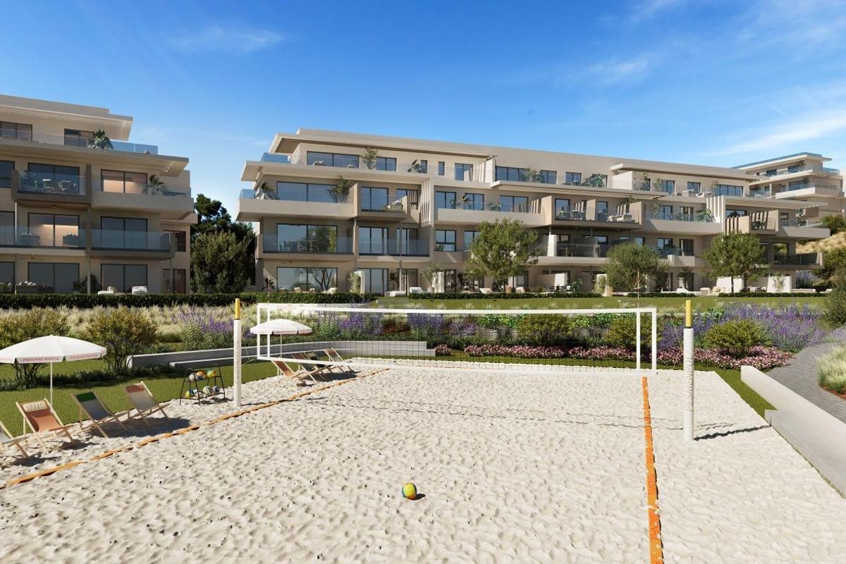 Beachvolleybalveld met ligstoelen bij luxe appartementen in Mijas, Costa del Sol, ideaal voor ontspanning.