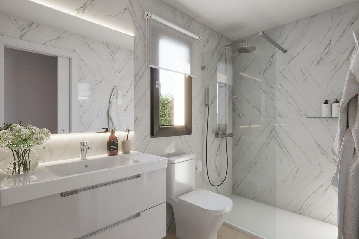 Modern bathroom in a 3-bed villa in Mazarron, Spain. Marble-look tiles, glass shower, and minimalist white vanity.