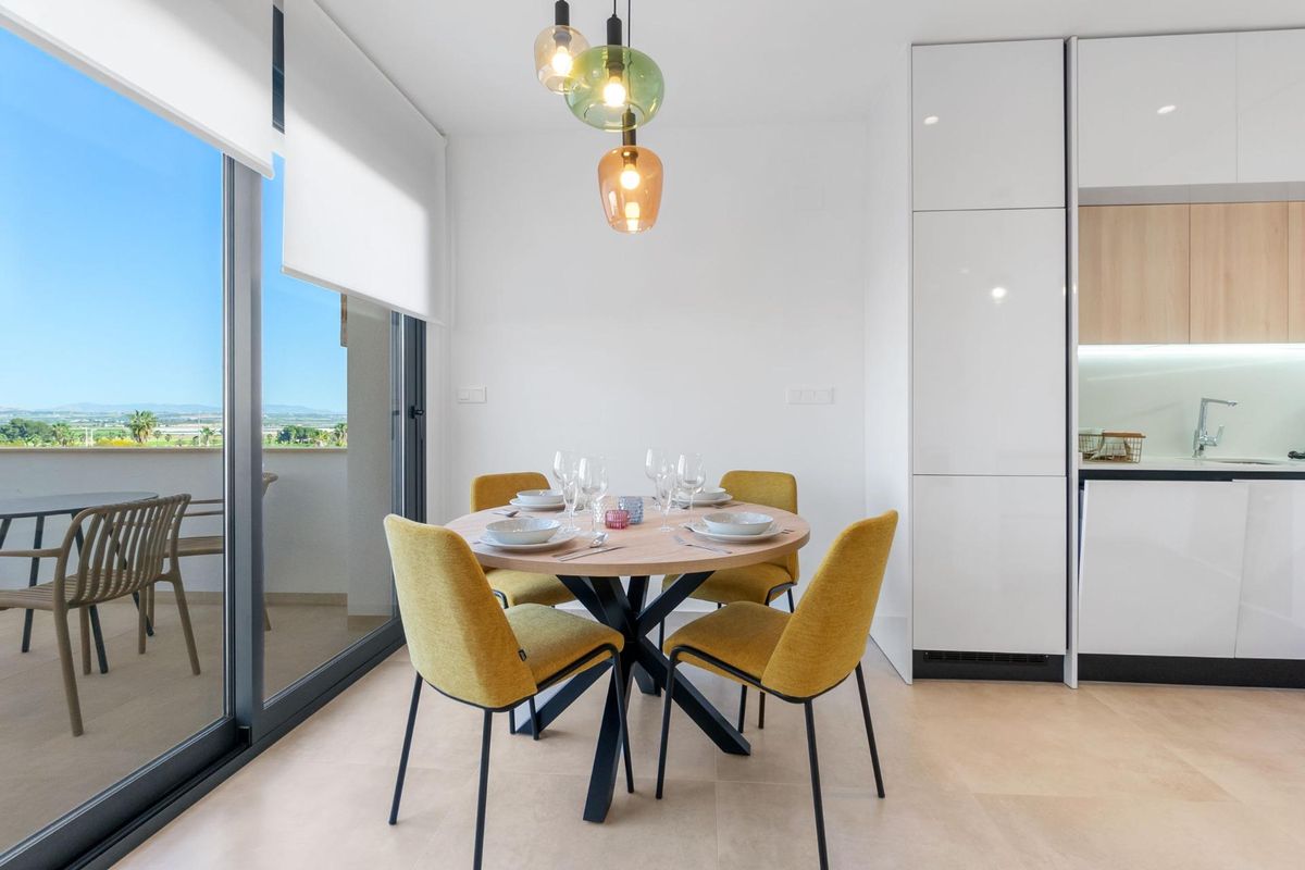 Eetruimte in een bungalow met een ronde tafel en stijlvolle stoelen, met schilderachtige uitzichten op de achtergrond.