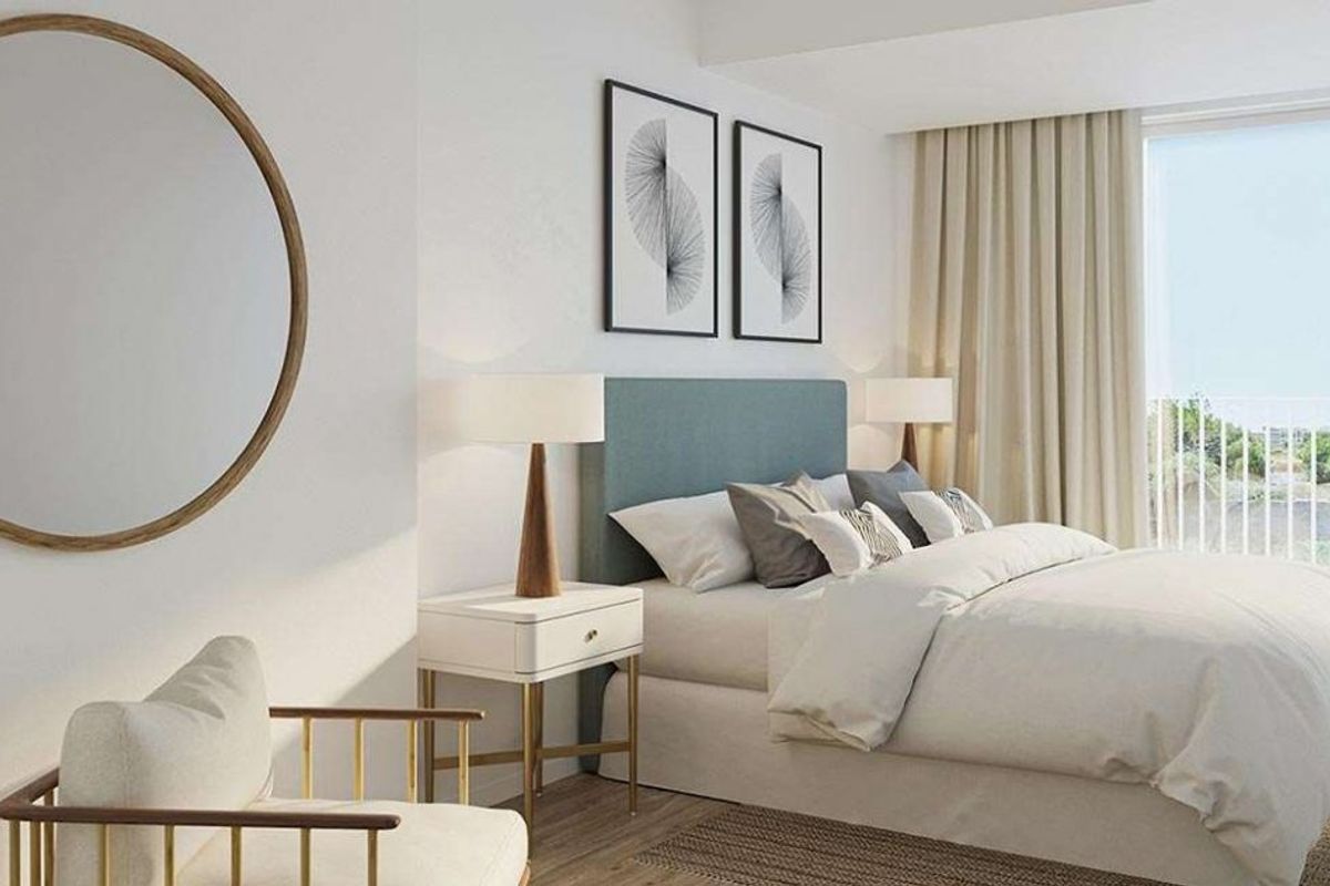 Gastvrije slaapkamer met een dubbel bed, stijlvolle lamp en natuurlijk licht in een penthouse in Jávea Xàbia.