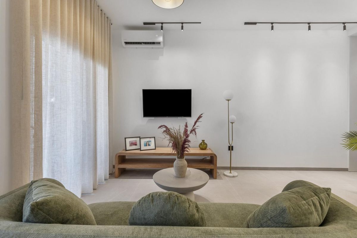 Gezellige woonkamer met comfortabele bank en tv in een gelijkvloers appartement in Torrevieja, Costa Blanca.