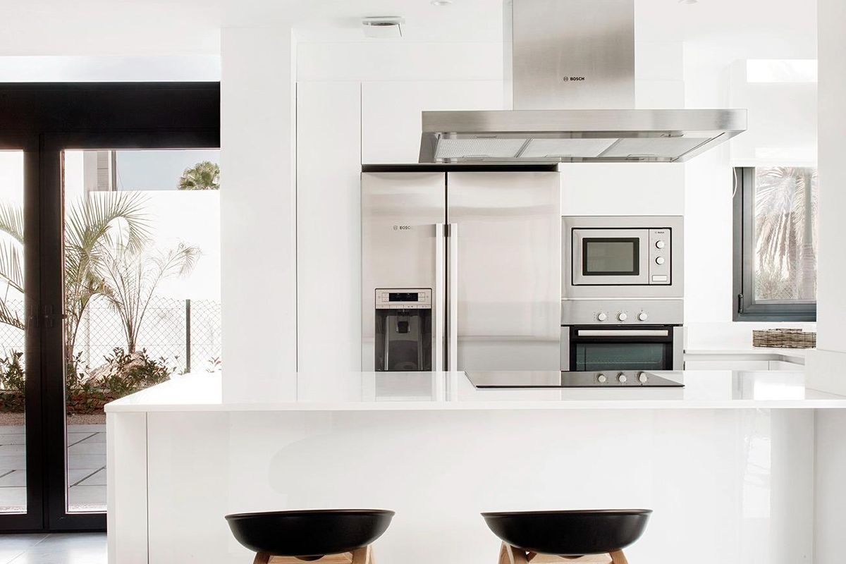 Stylish keuken met modern ontwerp, eilandzitplaatsen en uitzicht op de buitenlucht in villa in La Manga Club.