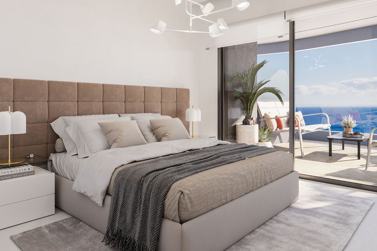 Moderne slaapkamer met uitzicht op de oceaan en toegang tot het terras in een 3-slaapkamerappartement in Calpe.