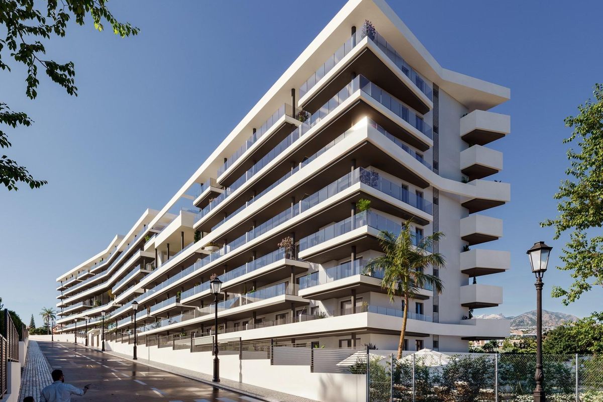 Stijlvol modern appartementencomplex in Fuengirola, Costa del Sol, met palmbomen langs de straat.