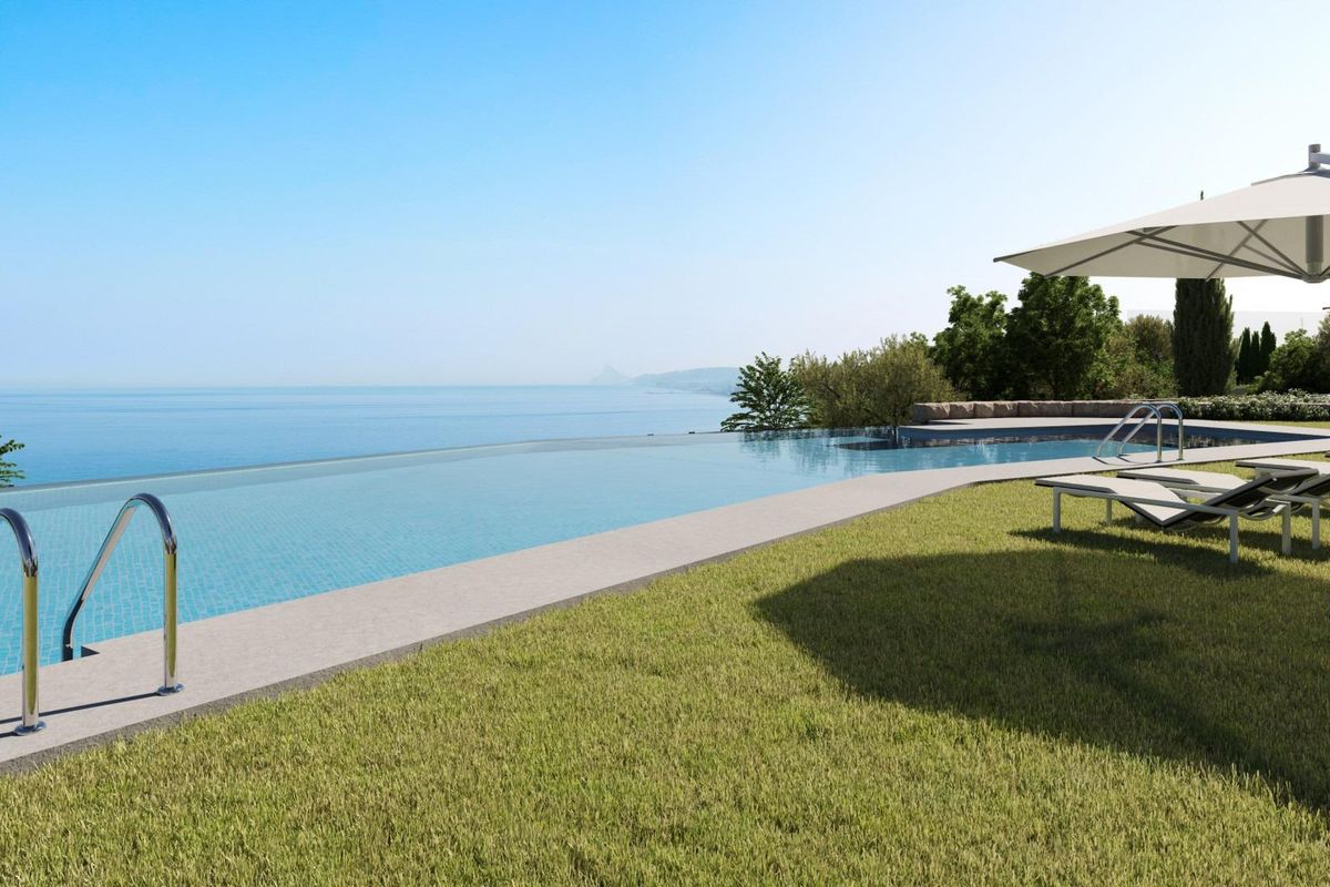 Infinity pool omgeven door weelderige tuinen bij een penthouse in Casares, met serene kustuitzichten in Costa del Sol.