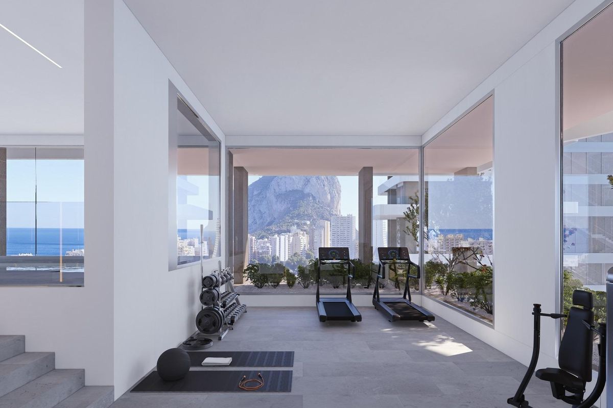 Moderne gym met uitzicht op een zwembad en kustzicht in dit stijlvolle appartement in Calpe.