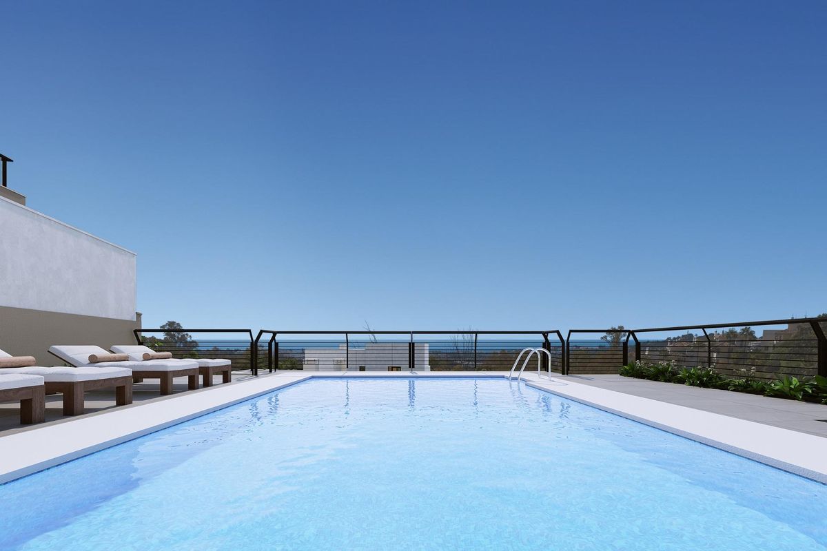 Penthouse zwembad met ligstoelen onder een heldere lucht in Marbella, Costa del Sol.