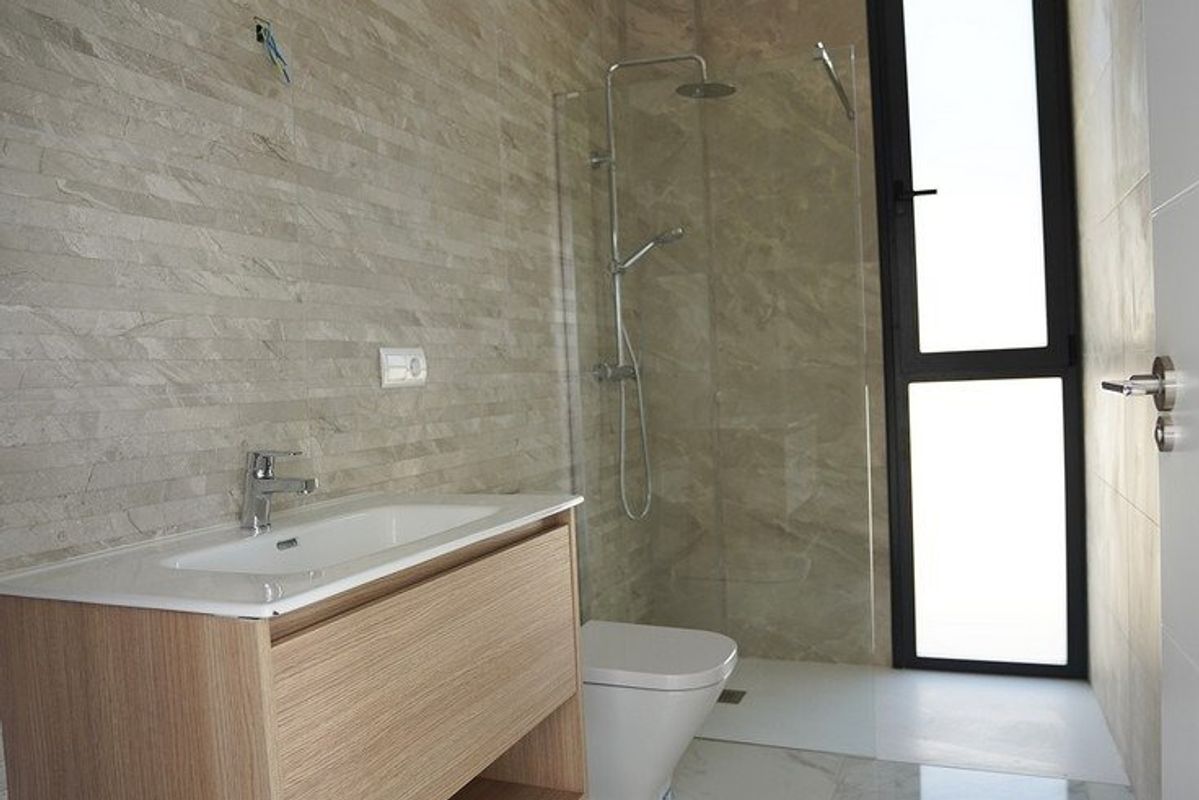 Hedendaagse badkamer met een schoon ontwerp, douche en houten wastafel in Polop.