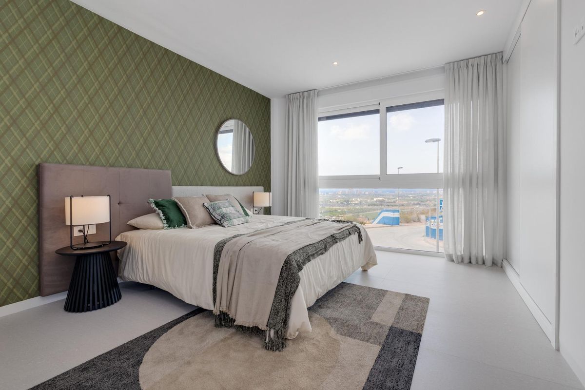 Gezellige slaapkamer met groene patroonwand en grote ramen in een 3-slaapkamer villa in Mutxamel, Costa Blanca.