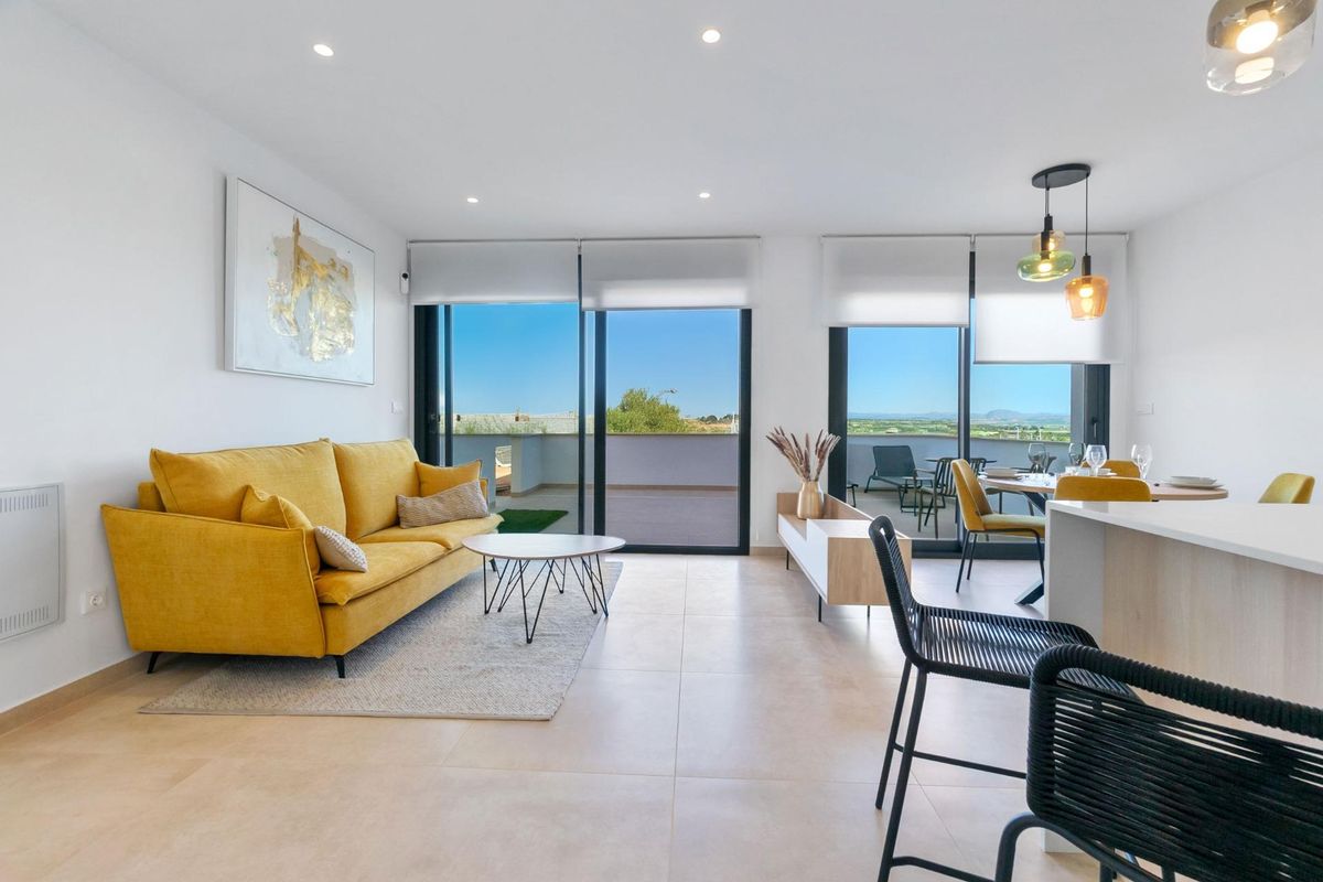 Gezellige woonkamer van een bungalow, met vrolijke decoraties en grote ramen die natuurlijk licht binnenlaten.